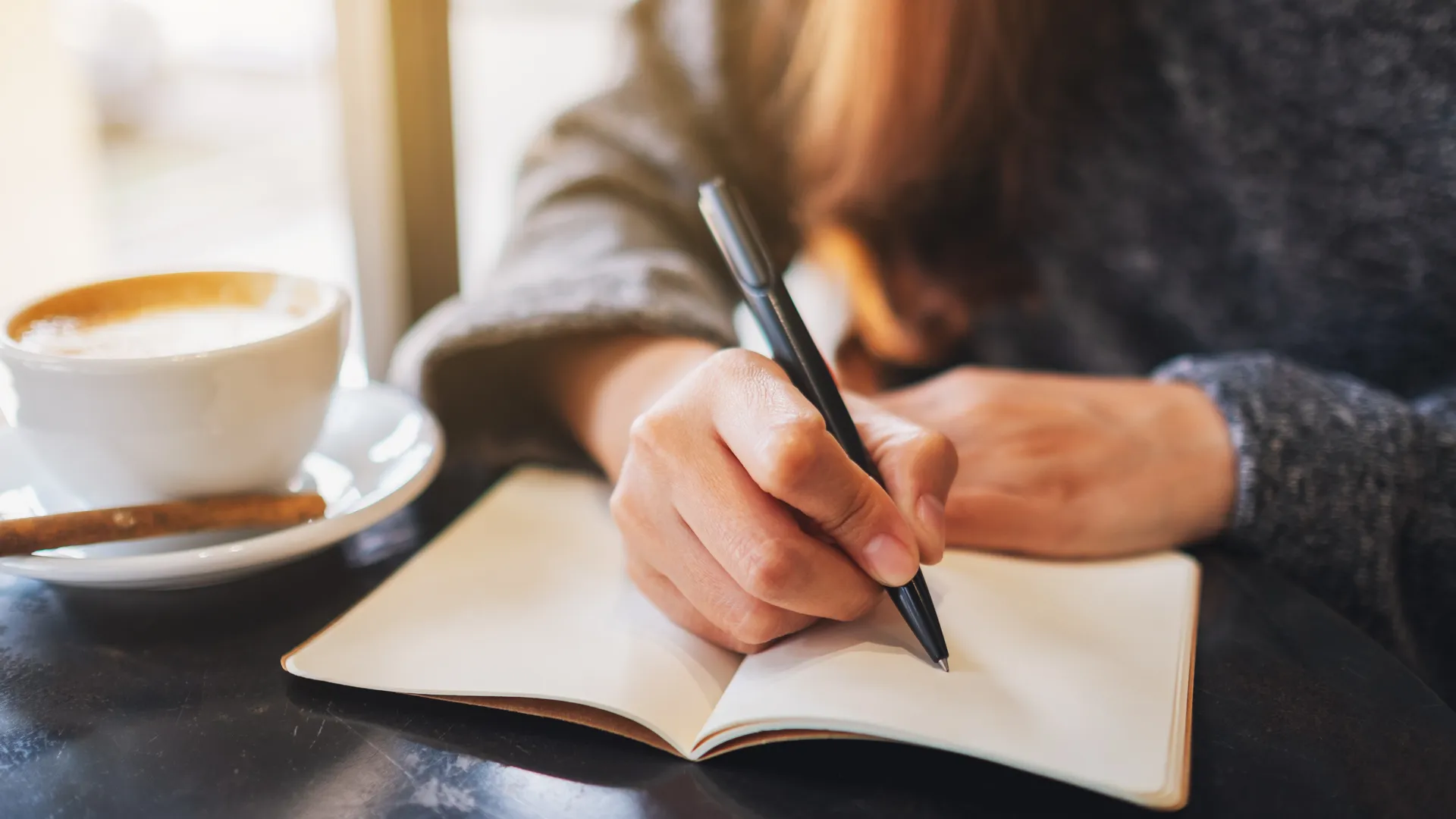Femme écrivant dans un carnet, concentrée – Ariella Thérapie | Thérapeute | Psychoénergéticienne | Villeneuve-Loubet | Provence-Alpes-Côte d'Azur | France